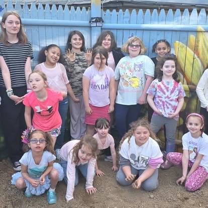 A group of children gathered at the garden fence